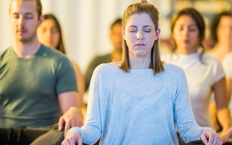 A group of people sitting and struggling with meditation.